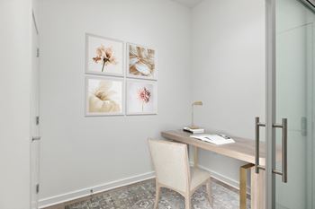 A white chair sits in front of a desk with a lamp on it.